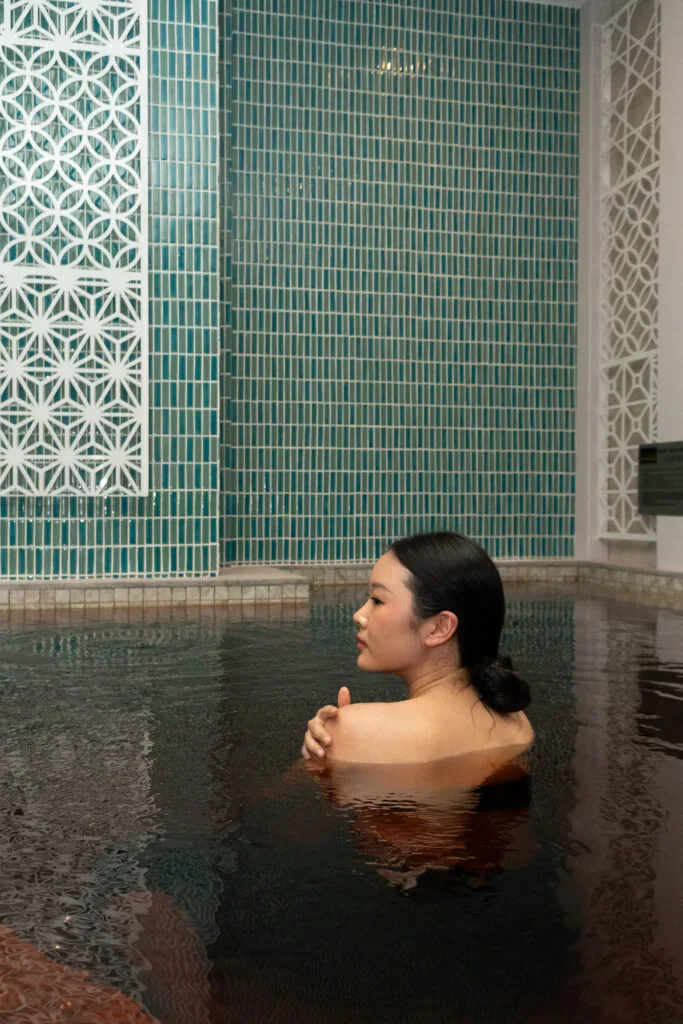 A guest relaxing in a warm onsen pool at Ichirin Wellness