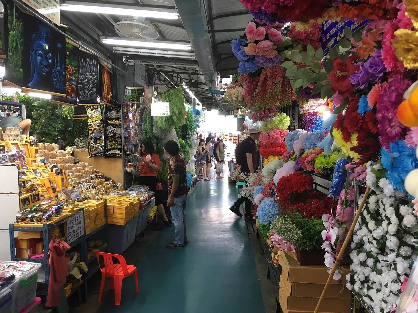 A busy aisle at Chatuchak Weekend Market with colorful stalls